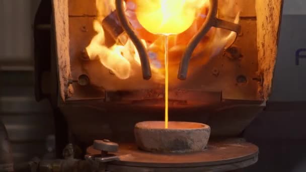 Roztopiony metal jest wsypywany do miski hutniczej w zakładzie do produkcji elementów ze srebra. — Wideo stockowe