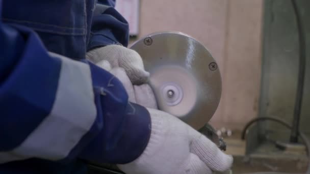 A worker burnishes the finished silver spoon with a machine-tool — Stock Video