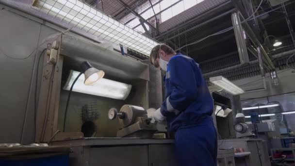 Robotnik w zakładzie uszlachetniający gotową srebrną łyżkę obrabiarką — Wideo stockowe