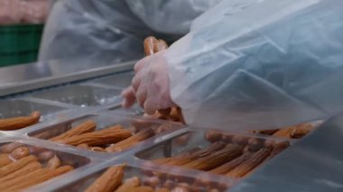 Et işleme fabrikasının işçileri hazır sosisleri plastik paketlere yerleştirdiler.