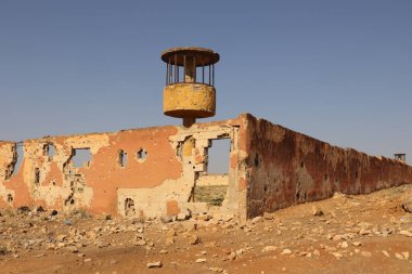 Suriye Halep Merkez Hapishanesi yakınlarında sayısız kurşunla delik deşik edilmiş bombalı askeri kışla duvarı. Ağır bombardıman ve savaş izleri taşıyor. Belgesel veya eğitici görseller için ideal.