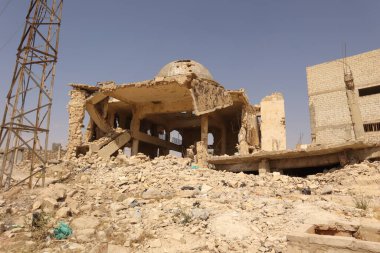 Suriye 'nin Halep kentindeki yıkık camii yoğun hava saldırılarıyla ağır hasar gördü. Harabe, yıkılmış beton ve harap olmuş bir kubbe savaşın şiddetini gösteriyor. Haber, belgesel ve çatışma farkındalığı için ideal.