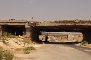 Halep, Suriye 'deki yıkılmış köprü ağır savaş hasarı ve kentsel yıkımı belgelemek için ele geçirildi. Çatışmanın altyapı, gazetecilik ve belgesel için ideal üzerindeki etkisini güçlü bir şekilde betimler