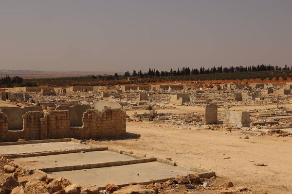 An abandoned refugee camp near Aleppo, Syria, showing ruins and destroyed shelters after the conflict ended. A powerful image symbolizing recovery, resilience, and the passage of time.