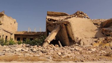 Halep 'teki yıkılmış bina, savaşın ortasında yıkılmış molozların arasında, erken inşa çalışmaları sırasında bir kamyon geçerken duruyor. Sahne, uzun Suriye savaşlarının etkisini ve çatışmaların düzeltilmesi hakkındaki belgeselin değerini gösteriyor.