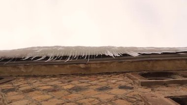 Eriyen buz saçaklarından Türkiye 'nin Erzurum kentinin çatısındaki bir çatıdan düşen sular, baharın erimesini, kış bitmesini, soğuk havayı ve iklim değişikliğini yakalıyor.