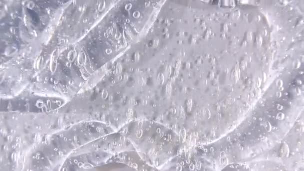 Crema de gel líquido transparente con micro burbujas a medida que se desliza lentamente hacia abajo. Macro Shot — Vídeo de stock