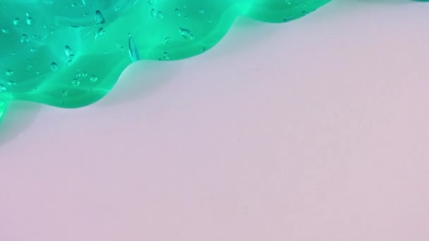 Прозора зелена гелева рідина з бульбашками, що течуть на білій поверхні. Макро Постріл — стокове відео