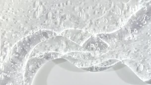 Creme de gel líquido transparente com micro bolhas enquanto desliza lentamente para baixo. Macro Shot — Vídeo de Stock