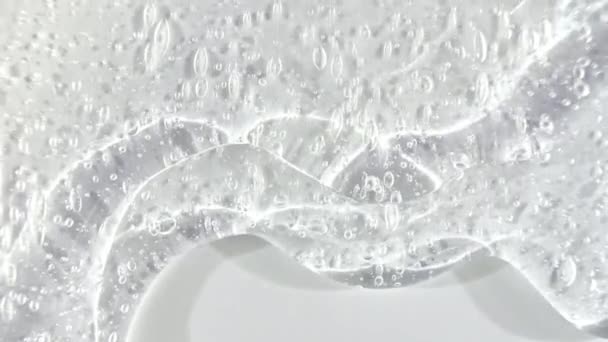 Crema de gel líquido transparente con micro burbujas a medida que se desliza lentamente hacia abajo. Macro Shot — Vídeo de stock