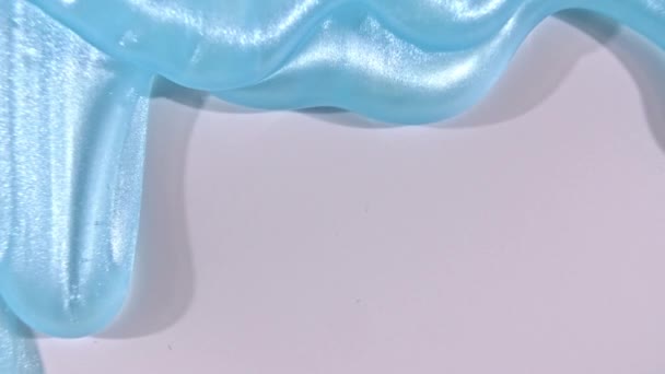 Biru gel krim cair dengan gelembung mikro mengalir di atas permukaan putih. Macro Ditembak — Stok Video