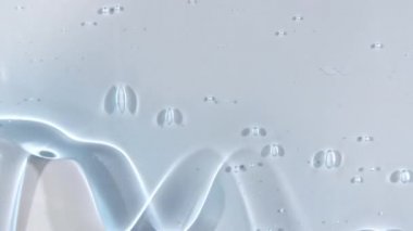 Yavaşça kayan mikro baloncuklu şeffaf sıvı jel kremi. Makro Vuruş