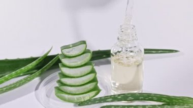 Aloe Vera yağlı cam şişe. Yakından Aloe Vera dilimlenmiş. Doğal tıbbi bitki. Organik kozmetik, alternatif tıp. 