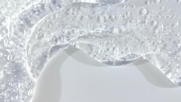 Líquido cosmético transparente do gel que flui para baixo em uma superfície branca. Macro Shot — Vídeo de Stock