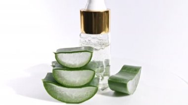 Aloe Vera 'nın dilimlenmiş hareket rotasyonu. Aloe Vera' nın yağ damlacıklarıyla birlikte kozmetik pipet. Doğal tıbbi bitki. Organik kozmetik, alternatif tıp.