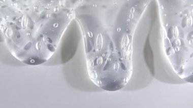 Yavaşça kayan mikro baloncuklu şeffaf sıvı jel kremi. Makro Vuruş