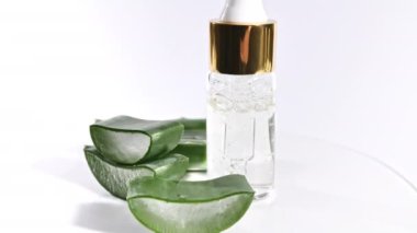 Aloe Vera 'nın dilimlenmiş hareket rotasyonu. Aloe Vera' nın yağ damlacıklarıyla birlikte kozmetik pipet. Doğal tıbbi bitki. Organik kozmetik, alternatif tıp.