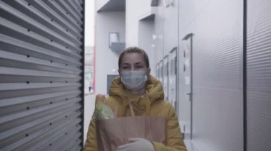 Süpermarketten alışveriş yapan genç bir kadın. Mağazadan alışveriş yapan maskeli bir kadın..