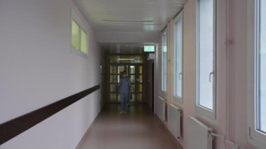 Maskeli bir doktor hastane koridorunda yürüyor.