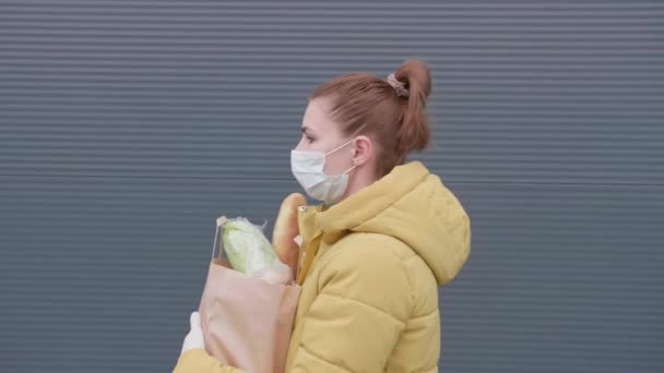 スーパーからの買い物で若い女性。店からの購入と仮面の女性. — ストック動画