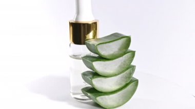 Aloe Vera 'nın dilimlenmiş hareket rotasyonu. Aloe Vera' nın yağ damlacıklarıyla birlikte kozmetik pipet. Doğal tıbbi bitki. Organik kozmetik, alternatif tıp.