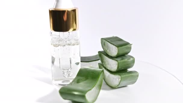 Rotación en movimiento de las rodajas de Aloe Vera Pipeta cosmética con gotas de aceite Primer plano de Aloe Vera. Planta medicinal natural. Cosmética ecológica, medicina alternativa. — Vídeo de stock