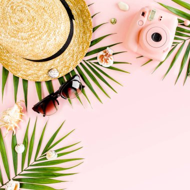 Kadın plaj aksesuarları: bikini, rattan çanta, hasır şapka, sarı arka planda tropik palmiye yaprakları. Yaz arkaplanı. 