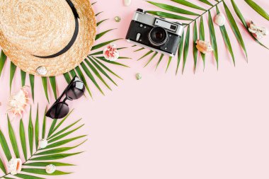 Kadın plaj aksesuarları: bikini, rattan çanta, hasır şapka, sarı arka planda tropik palmiye yaprakları. Yaz arkaplanı. 