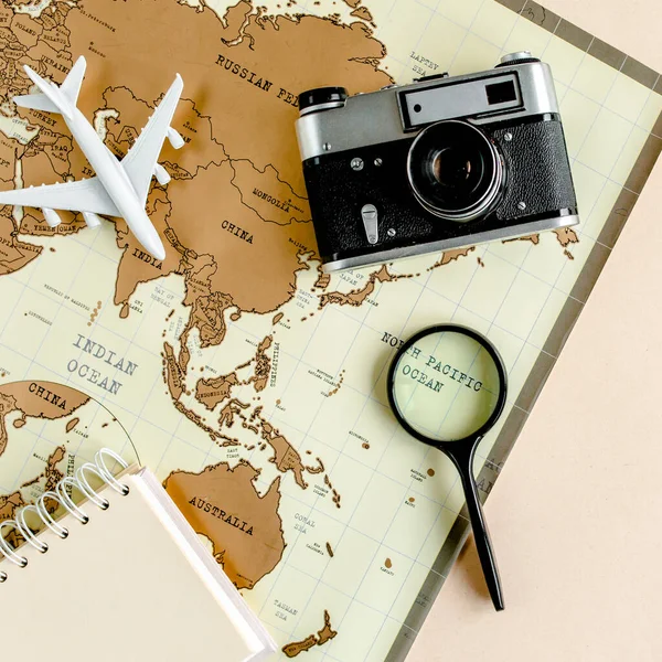 Planificación de vacaciones, plan de viaje, vacaciones de viaje utilizando el mapa del mundo junto con otros accesorios de viaje. Vista superior, plano. — Foto de Stock