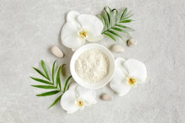 Spa tedavisi konsepti. Doğal organik kaplıca ürünleri ve yukarıdan gri mermer masa üzerinde tropik palmiye yaprakları. Spa arkaplan, düz yatış, üst 