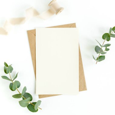 Sahte davetiye, boş tebrik kartı ve yeşil yapraklar okaliptüs. Düz yatış, üst görünüm.