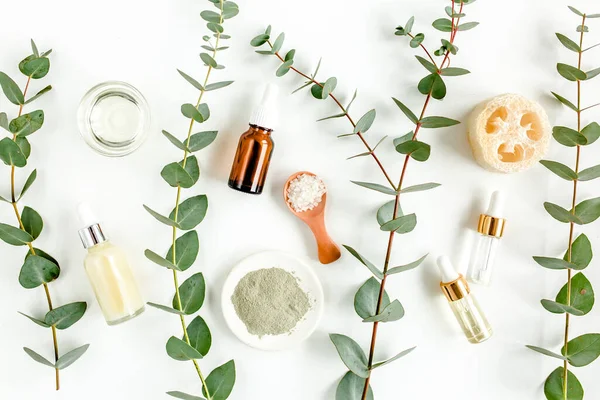 Eucalyptus essential oil, eucalyptus leaves on white background. Natural, Organic cosmetics products. Medicinal, Natural Serums. Flat lay, top view. — Stock Photo, Image
