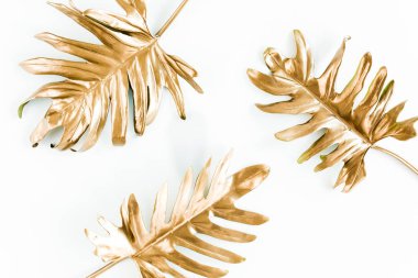 Beyaz arka planda altın tropik palmiye yaprakları. Düz konum, üst görünüm minimum konsept.