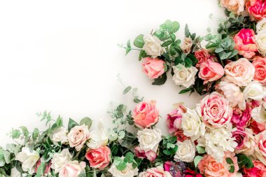 Beyaz arka planda pembe, bej gül tomurcuklarından oluşan çiçek deseni. Düz yatış, üst görünüm.