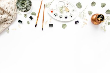 suluboyalı masa. Fırçalar, sulu, yapraklar okaliptüs. Düz kompozisyon, dergiler, sosyal medya. Merkez ofis çalışma alanı. düz yatış, üst görünüm