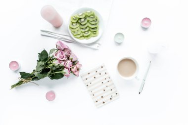 Ofis masası. Bilgisayar, bilgisayar. Düz kompozisyon, sosyal medya. Üst Manzara. Moda, gül buketi, defter, beyaz arka planda kahve..