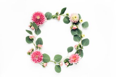 Beyaz arka planda pembe çiçek tomurcukları, dalları ve yaprakları olan yuvarlak bir çerçeve. Düz uzan, üst görünüm