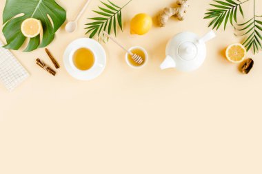 Nane, zencefil, limon, bal ve sarı arka planda diğer otlarla birlikte bitki çayı. Düz yatış, üst görünüm.