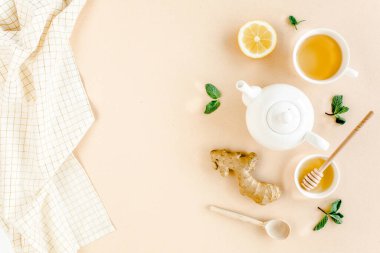 Nane, zencefil, limon, bal ve sarı arka planda diğer otlarla birlikte bitki çayı. Düz yatış, üst görünüm.