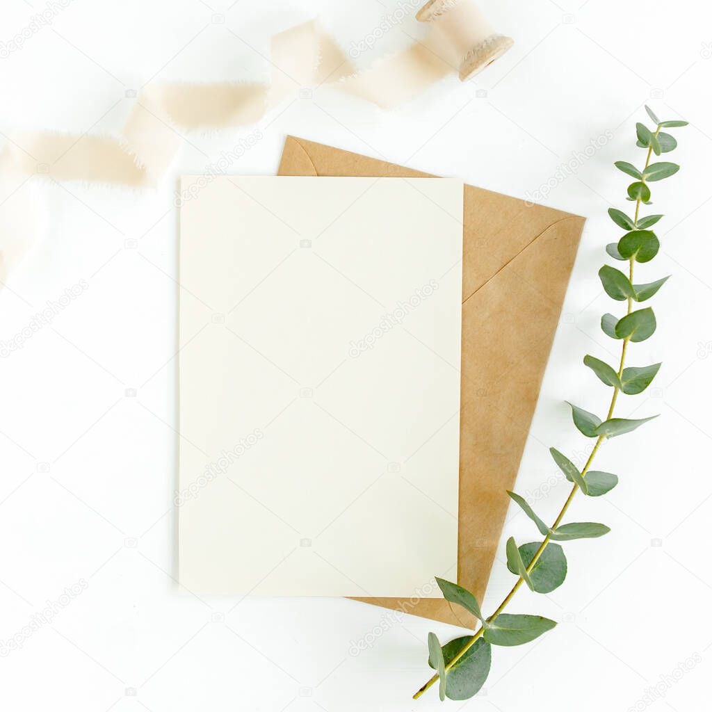 Mockup invitation, blank greeting card and green leaves eucalyptus. Flat lay, top view.