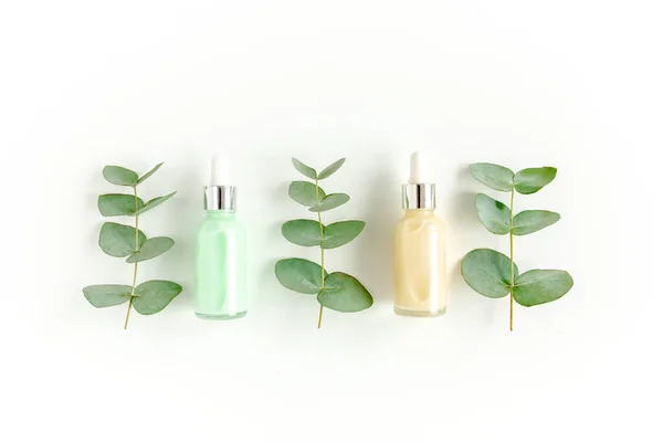 Olio essenziale di eucalipto, foglie di eucalipto su fondo bianco. Prodotti cosmetici naturali e biologici. Medicinale, sieri naturali. Posa piatta, vista dall'alto. — Foto Stock