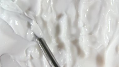 Sıvı kremin hareketi, dönüşümlü beyaz kozmetik doku. Kaplama, karalama geçmişi. Organik kozmetik, ilaç. Üst Manzara. 4K UHD video
