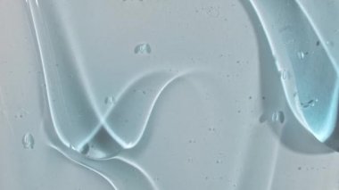 Sıvı krem jel, beyaz bir yüzeyde kabarcıklar akan mavi kozmetik doku. Makro Vuruş
