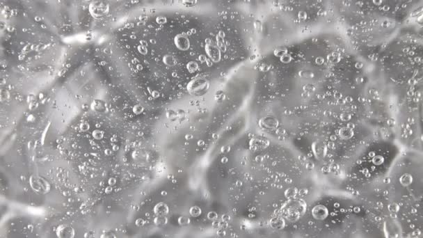 Moto del gel alla panna liquido, struttura cosmetica bianca con rotazione di bolle. Cosmetici biologici, medicina. Vista dall'alto. Macro Shot — Video Stock