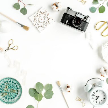 Seramik yaprak canavarlı çalışma alanı, retro kamera, okaliptüs yaprağı, beyaz arka planda aksesuarlar. Düz konum. Üst görünüm