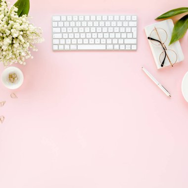 Ofis masasında bilgisayar, leylak ve dosya var. Dergiler. Üst Manzara Düz Yatıyordu. Merkez ofis çalışma alanı. Pembe arka planda kadın moda aksesuarları