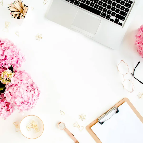 Ruang kerja dengan papan klip, laptop, bouquet hydrangea, aksesoris pada latar belakang putih. Meja wanita yang bergaya. Berbaringlah. Tampilan atas. — Stok Foto