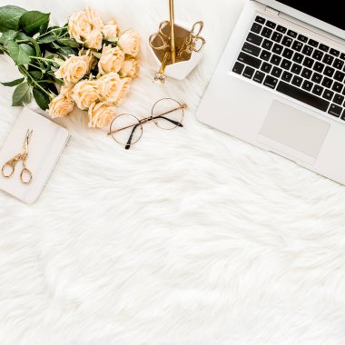 Dizüstü bilgisayarı, gülleri, altın aksesuarları, günlüğü, bilgisayarı, beyaz arka planda gözlüğü olan kadın çalışma alanı. Düz uzanmış kadınların ofis masası. Üst görünüm