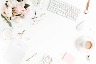 Düz uzanmış kadınların ofis masası. Bilgisayarlı kadın çalışma alanı, pembe şakayık buketi, beyaz arka planda aksesuarlar. Üst görünüm kadınsı arkaplan.