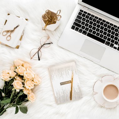 Dizüstü bilgisayarı, gülleri, altın aksesuarları, günlüğü, bilgisayarı, beyaz arka planda gözlüğü olan kadın çalışma alanı. Düz uzanmış kadınların ofis masası. Üst görünüm